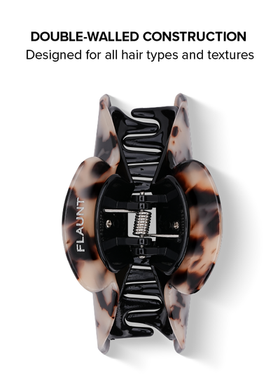 Blonde tortoise shell claw clip with black double-walled interior mechanism, shown from top view.