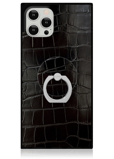 Black crocodile textured phone case with white circular ring stand attached to center, shown with silver smartphone.