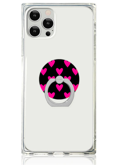 Clear phone case with black circular ring stand decorated with pink hearts.