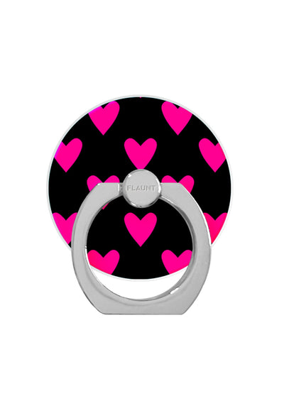 Black circular phone ring stand with bright pink hearts pattern and gray metal loop attachment.