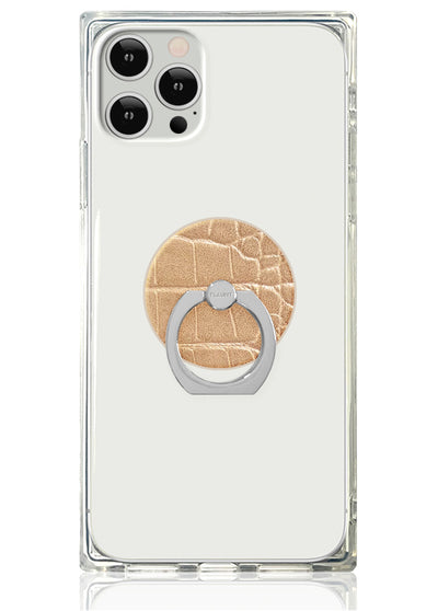 Tan crocodile-textured circular phone ring stand with silver metal band attached to clear phone case.