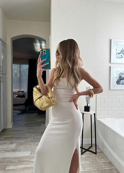 Turquoise iPhone case with gilded edges held by a person taking a mirror selfie in a bathroom.