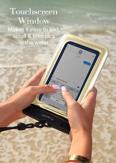Gold metallic waterproof phone pouch with touchscreen window held in hand at beach.