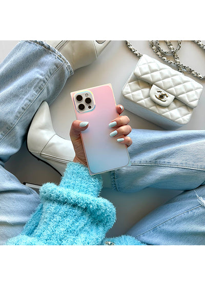 Square phone case with iridescent satin finish in pink and blue gradient, held in hand showing camera cutout and metallic fra