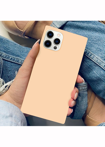 Nude almond phone case with square shape and triple camera cutout, held in hand against denim background.