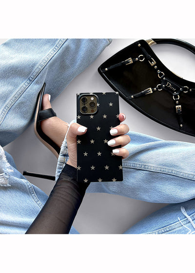 Black matte iPhone case with white star pattern held in hand, showing camera cutouts on back.