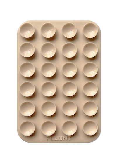 Beige silicone mount with grid of 24 suction cups and rounded corners, branded "FLAUNT" at bottom.