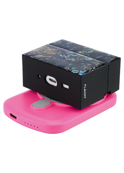 Pink rectangular MagSafe battery pack with USB-C port and charging indicator dots, shown with black packaging box above it.