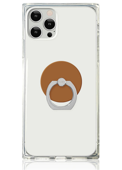 Clear phone case with caramel-colored circular adhesive ring stand attached to back.