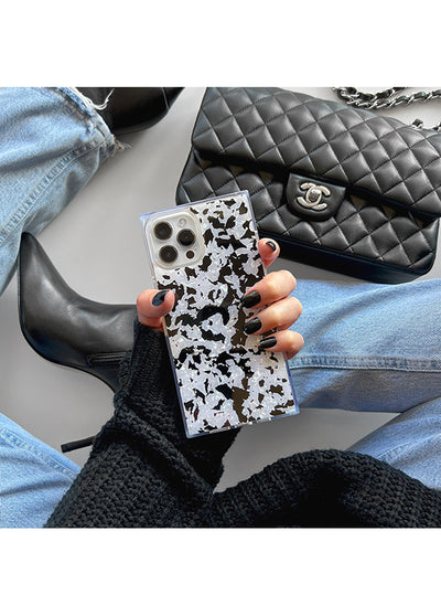 iPhone case with black and white tortoise shell pattern and square shape, held in hand displaying camera cutouts.
