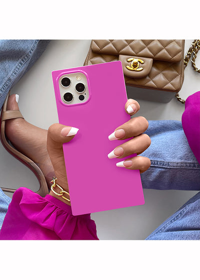 Fuchsia square iPhone case with metallic camera ring held in hand, showing four camera lens cutouts.