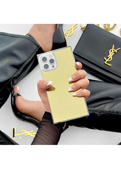 Gold mirror iPhone case with square shape held in hand, showing metallic gold back and silver camera lens area.